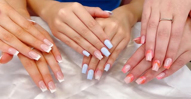 Three sets of freshly manicured hands with French tips, pale blue and coral nails